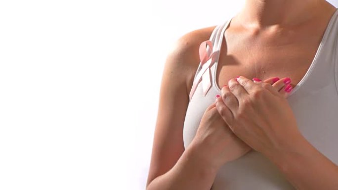粉红丝带乳腺癌，年轻女子双手紧握胸部，呼吸缓慢