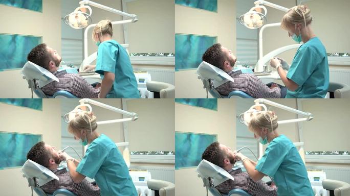 女牙医在牙科诊所钻病人的牙。