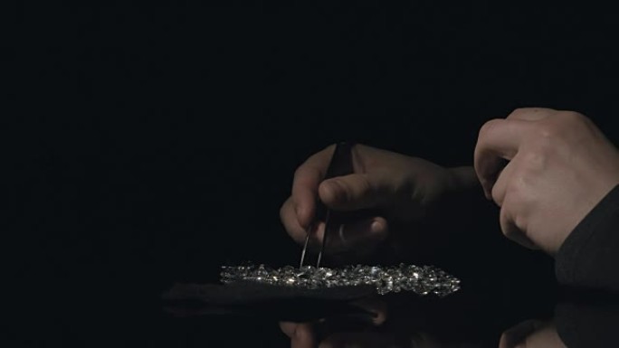 侧视图: 鉴定人宝石将钻石和水晶倒在桌子上，并对其进行评估
