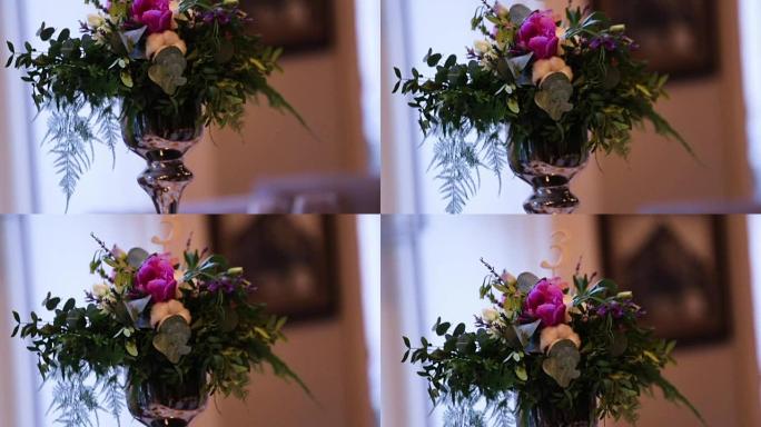 精美的婚礼装饰由不同种类和颜色的花朵制成，放在高档餐厅的婚礼桌上。