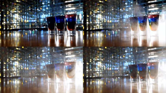 五颜六色的鸡尾酒在烟雾中的前酒吧拍摄