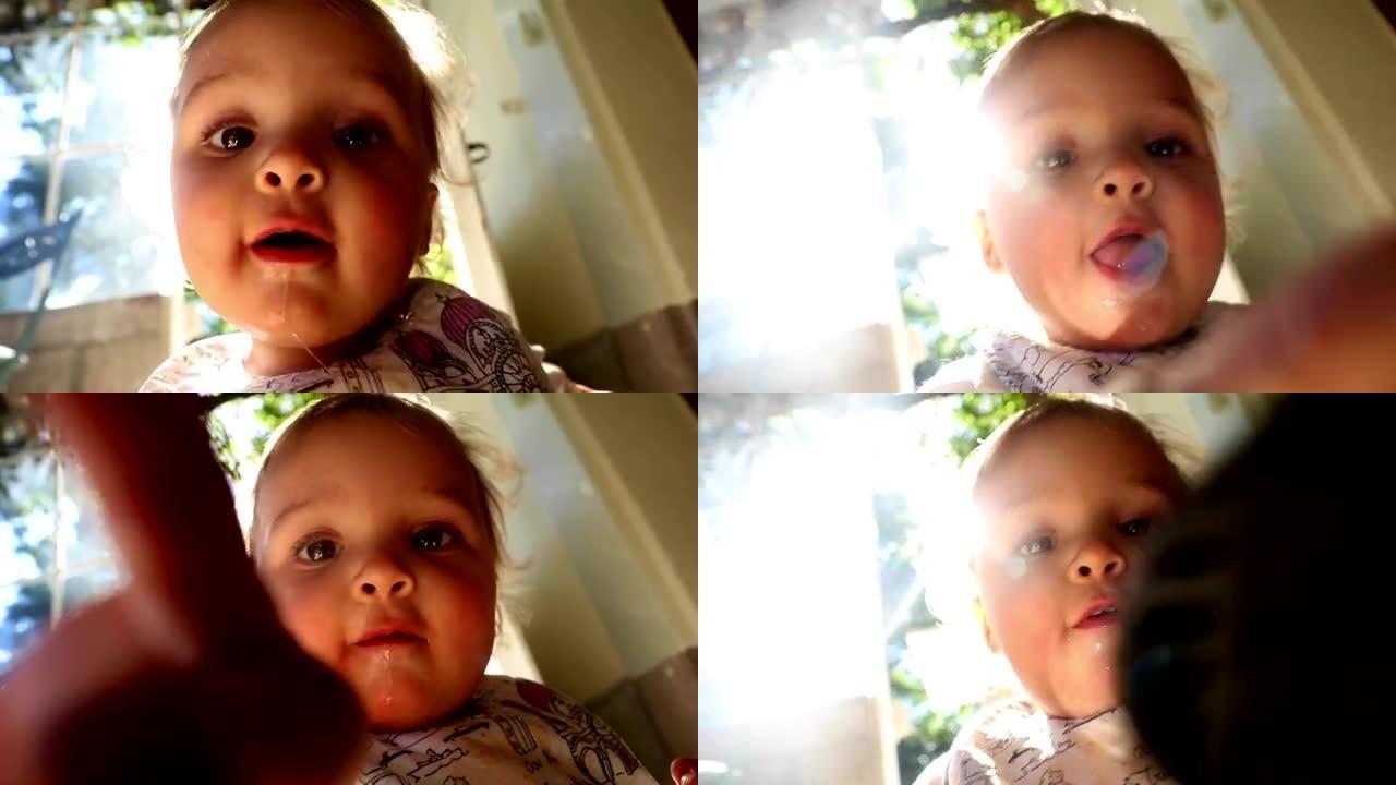 试图触摸相机的宝贝。相机镜头上的婴儿手指。美丽的镜头耀斑