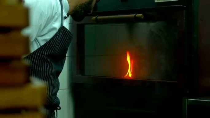 餐厅厨师在烤箱里看着火