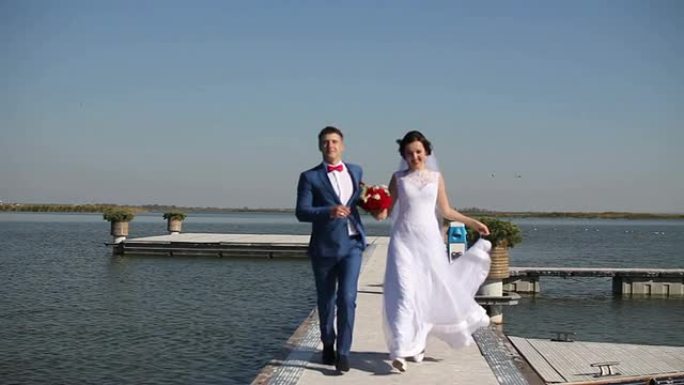 快乐的新娘和新郎在从码头回来的路上奔跑