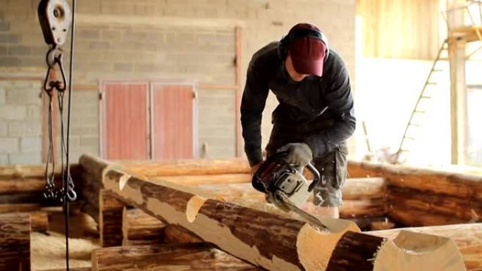 男人为未来的家切断了光束电锯。木结构建筑工程