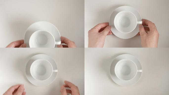 俯视图: 人的手将白色茶杯放在白色桌子上