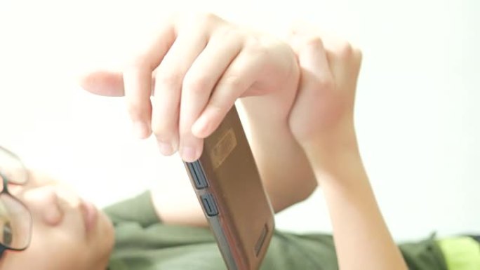 亚洲男孩使用智能手机的数字游戏