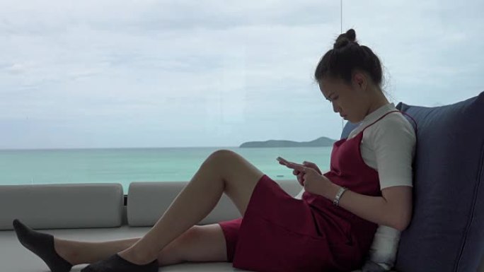 4k: 在蓝海海滩拥有智能手机的亚洲女性