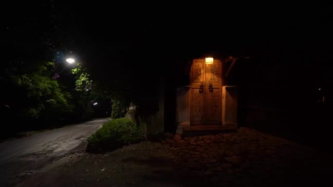 旧门被路灯照亮，在马路旁边。
