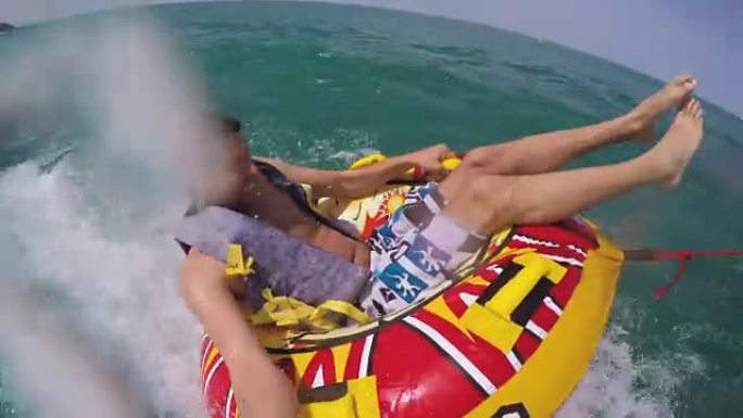 男子坐在充气环上，被一艘船拖入水中，用Go Pro相机记录自己