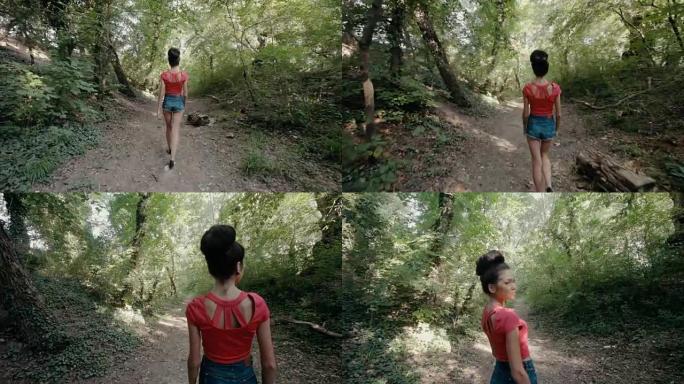 性感的年轻女子走在树林里的小路上