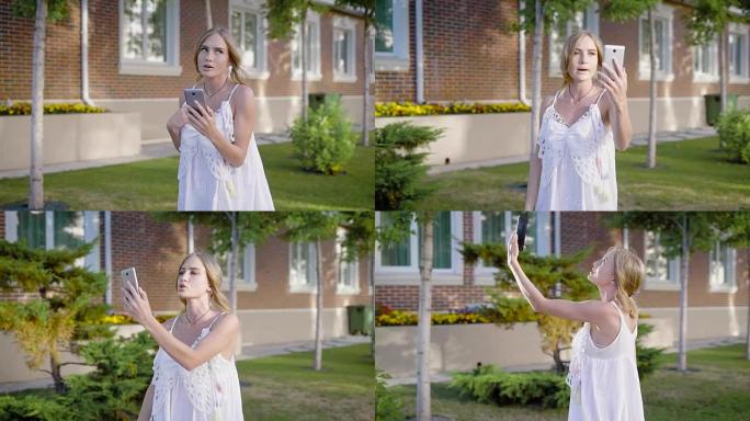 穿着白色蕾丝连衣裙的年轻迷人女子去散步，在视频聊天中与她的朋友交谈