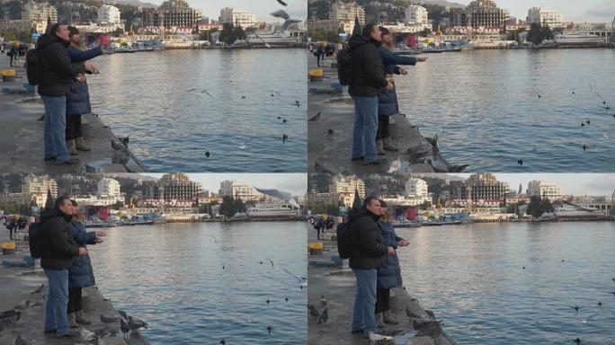 一个女人和一个男人在喂海鸥
