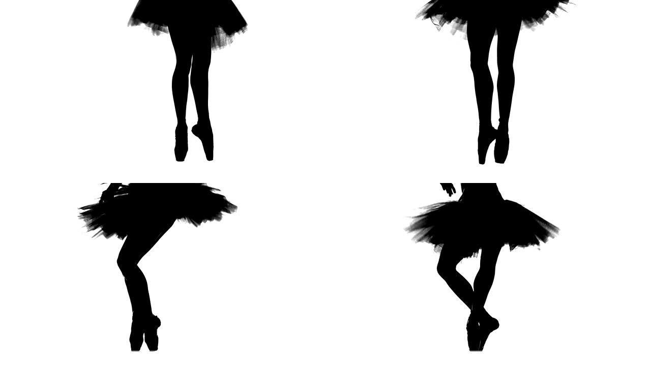 剪影芭蕾舞演员跳舞，腿和鞋子上的特写镜头，以尖姿势站立。慢动作