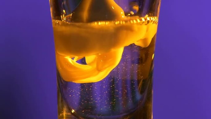 调酒师正在将饮料倒入带有白色液体的玻璃杯中，慢动作