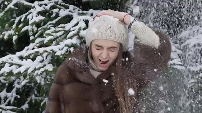 一团雪落在站在树附近的女孩身上。慢动作