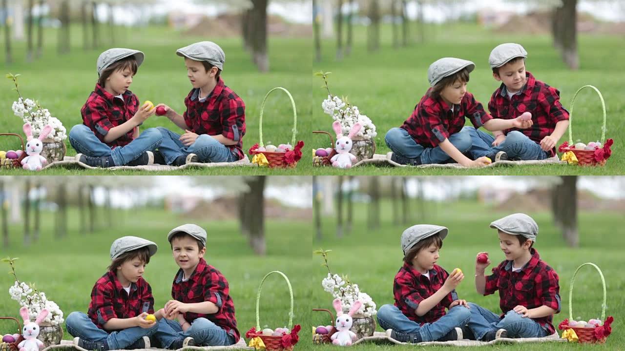 两个孩子，男孩兄弟，在公园里玩复活节彩蛋，美丽的春天盛开的花园