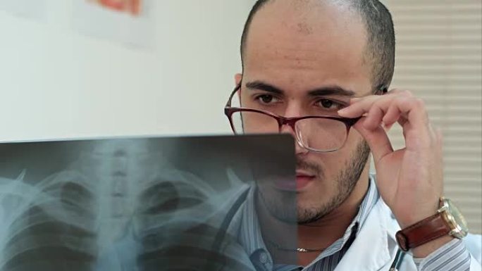 戴眼镜的年轻男医生仔细分析x射线图像