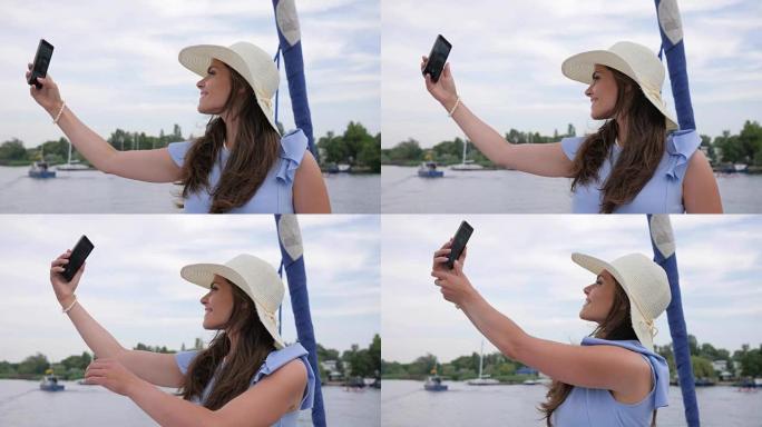 好女孩在游艇上自拍，手中的android女人，节日图片，女人在户外在手机上拍照