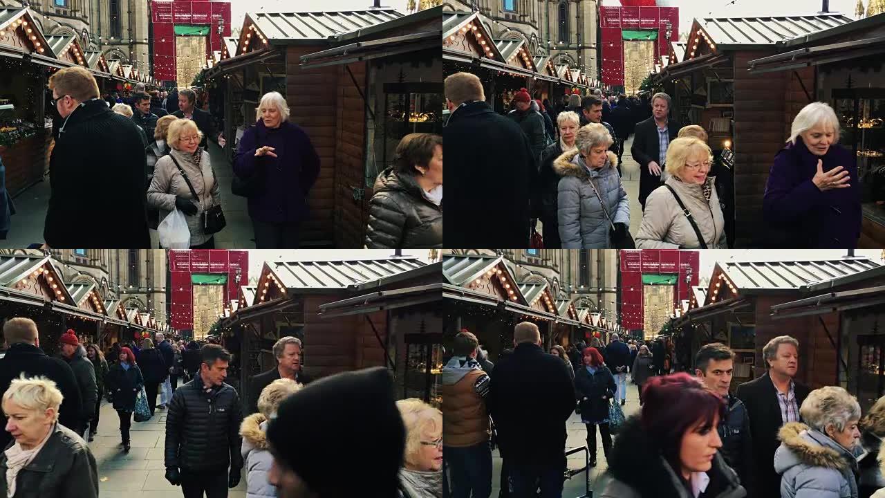 英国曼彻斯特-2016年12月16日。在阿尔伯特广场曼彻斯特市政厅前的圣诞市场上，购物者的照片。20