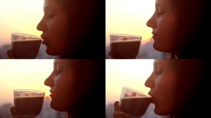 日落城剪影窗边喝咖啡的漂亮女孩的慢动作