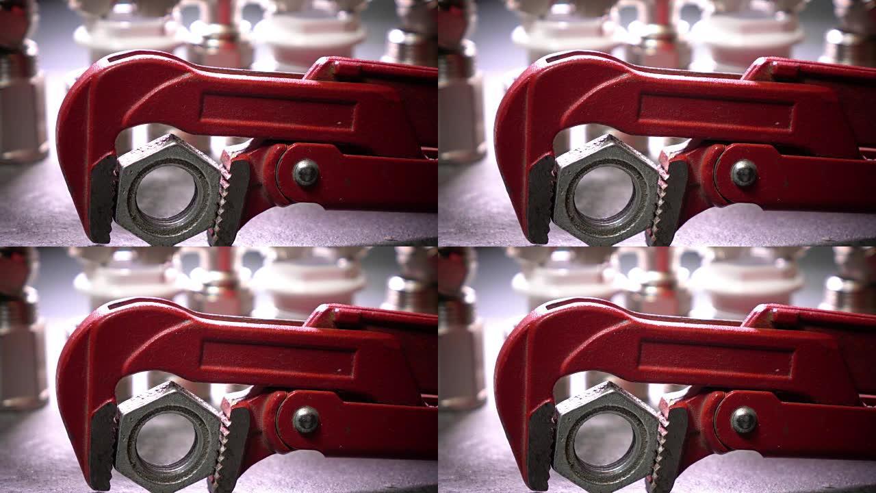 红色金属制品可调扳手，用于卫生工程，背景是水切断和供水连接截止阀