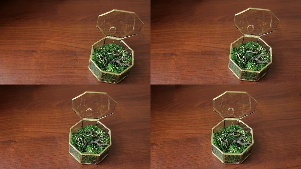 玻璃盒子里的结婚戒指装满了桌子上的草