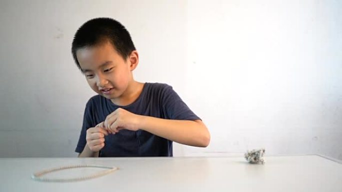 亚洲男孩坐在桌子前玩磁珠