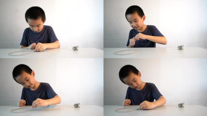 亚洲男孩坐在桌子前玩磁珠