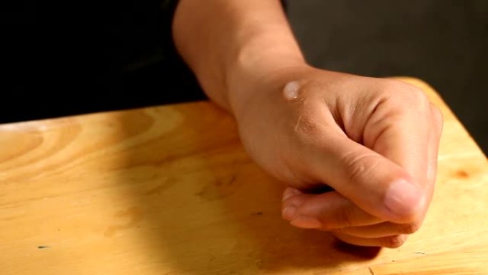 特写亚洲女性的手握和使用保湿霜。