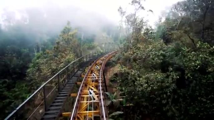 移动的旅客列车通过山区的森林铁路行驶。火车去车库。多云的天气。