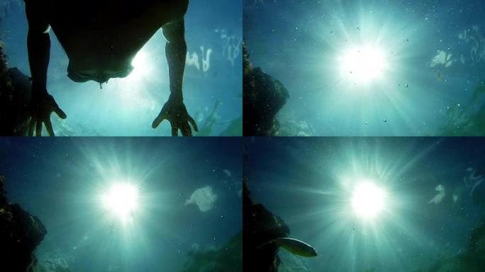 水下镜头: 一段时间后，一名男子潜水并游泳，一条鱼经过