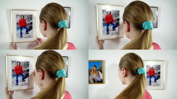 十几岁的女孩看着挂在墙上的家庭相框照片