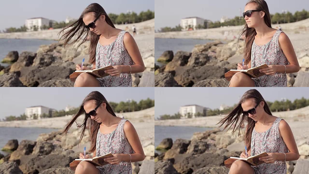 勇女人在海滩上的日记中做笔记