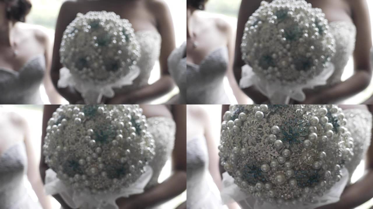 黑人妇女手持装饰人造婚礼花束。婚礼花束人造花。新娘拿着令人惊叹的白色婚礼装饰花束人造花和金属。选择性