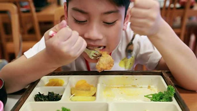 快乐亚洲儿童在餐厅吃寿司