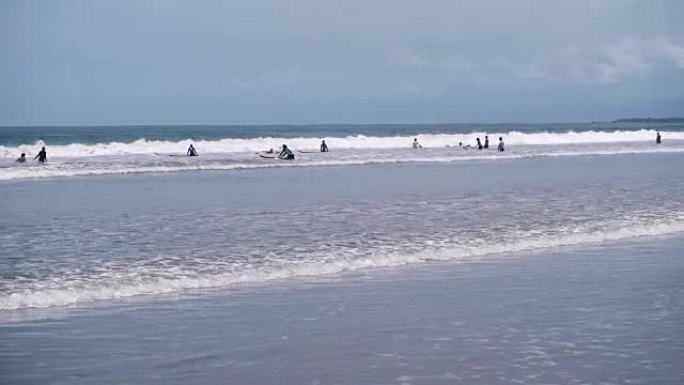 大量冲浪者试图在海岸附近赶上海浪。人们在度假时冲浪，只是在海里游泳