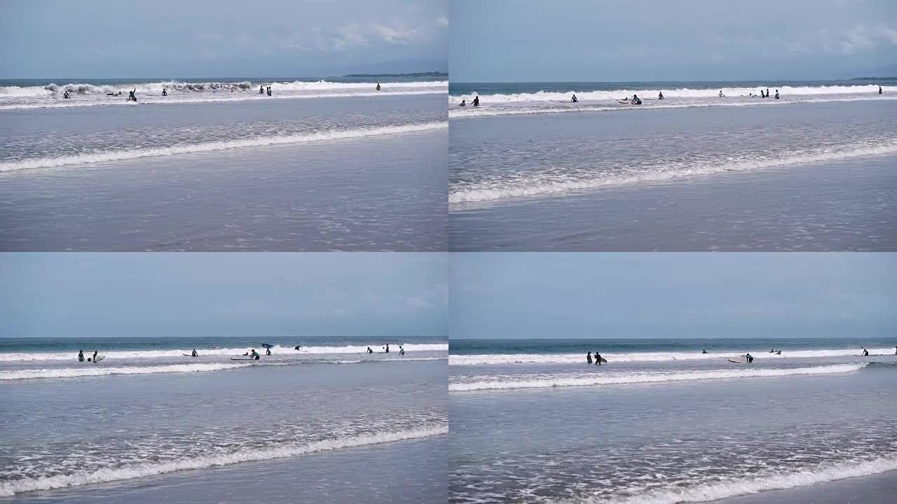 大量冲浪者试图在海岸附近赶上海浪。人们在度假时冲浪，只是在海里游泳