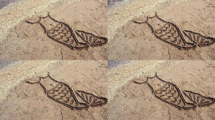 美人鱼在沙子上画画。