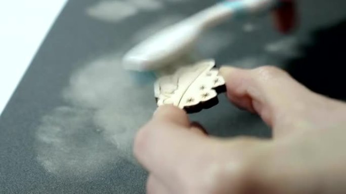 艺术家在砂纸上打磨后用刷子清洁木制工艺品