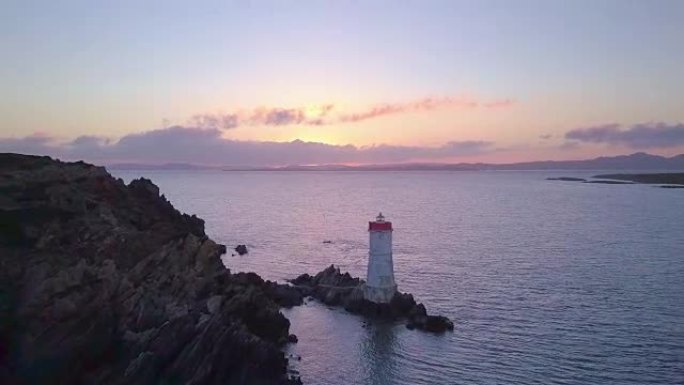 日落时灯塔的无人机拍摄的空中视频。意大利撒丁岛翡翠海岸。