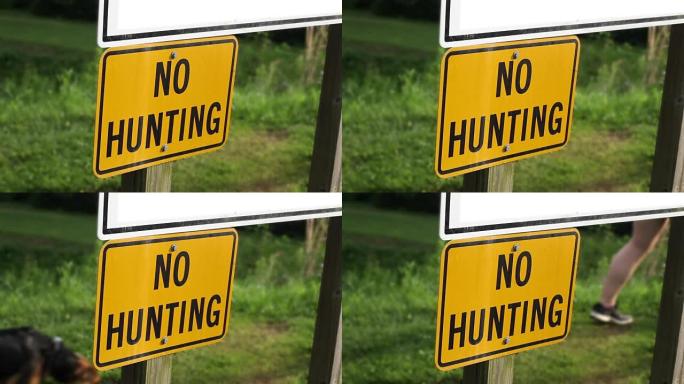 女子走过一个禁止狩猎的标志在州立公园