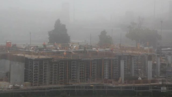 在雾中工作的新地板上的建筑工人