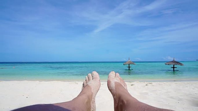 热带阳光岛白色沙滩上的POV放松了脚。完美假期