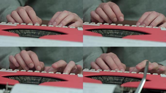 男性的手在红色打字机上打字