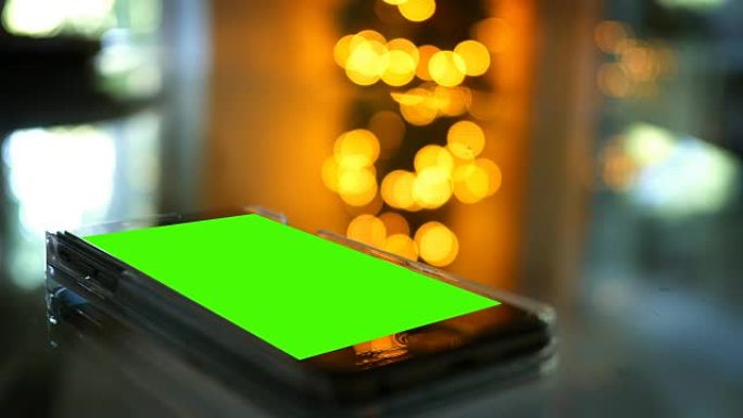 圣诞节前后躺在桌子上的通用绿屏智能手机