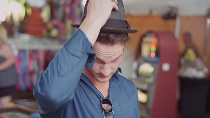 一个年轻人在集市上试戴帽子