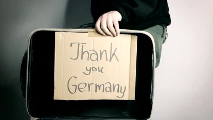 打开难民手提箱，并在纸板上留言谢谢德国