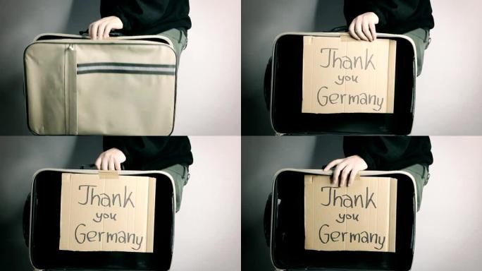 打开难民手提箱，并在纸板上留言谢谢德国