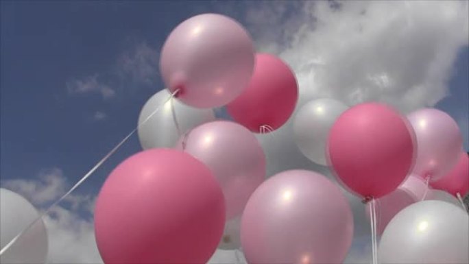 粉红色和白色的充气球的线在风的打击天空和云彩摆动